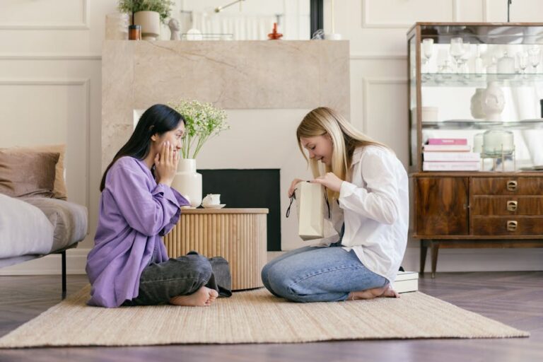 Two young women exchanging birthday gifts in a cosy living room, celebrating a new friendship with a wrapped present