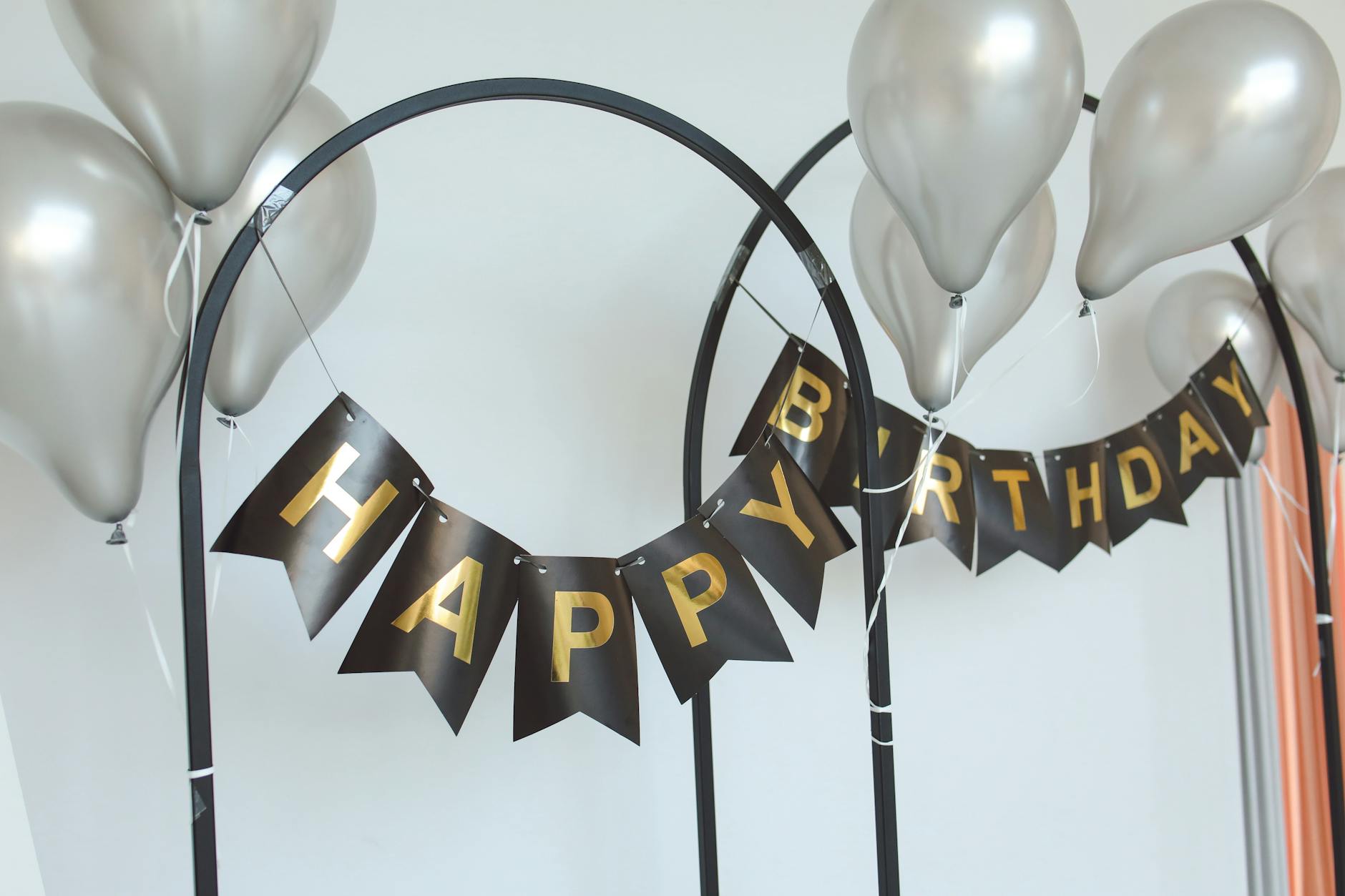 Elegant birthday party setup with metallic balloons and a Happy Birthday banner, showing decoration ideas