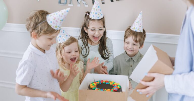 Group of kids celebrating a birthday party with cake, party hats and colourful decorations — best birthday party ideas for children