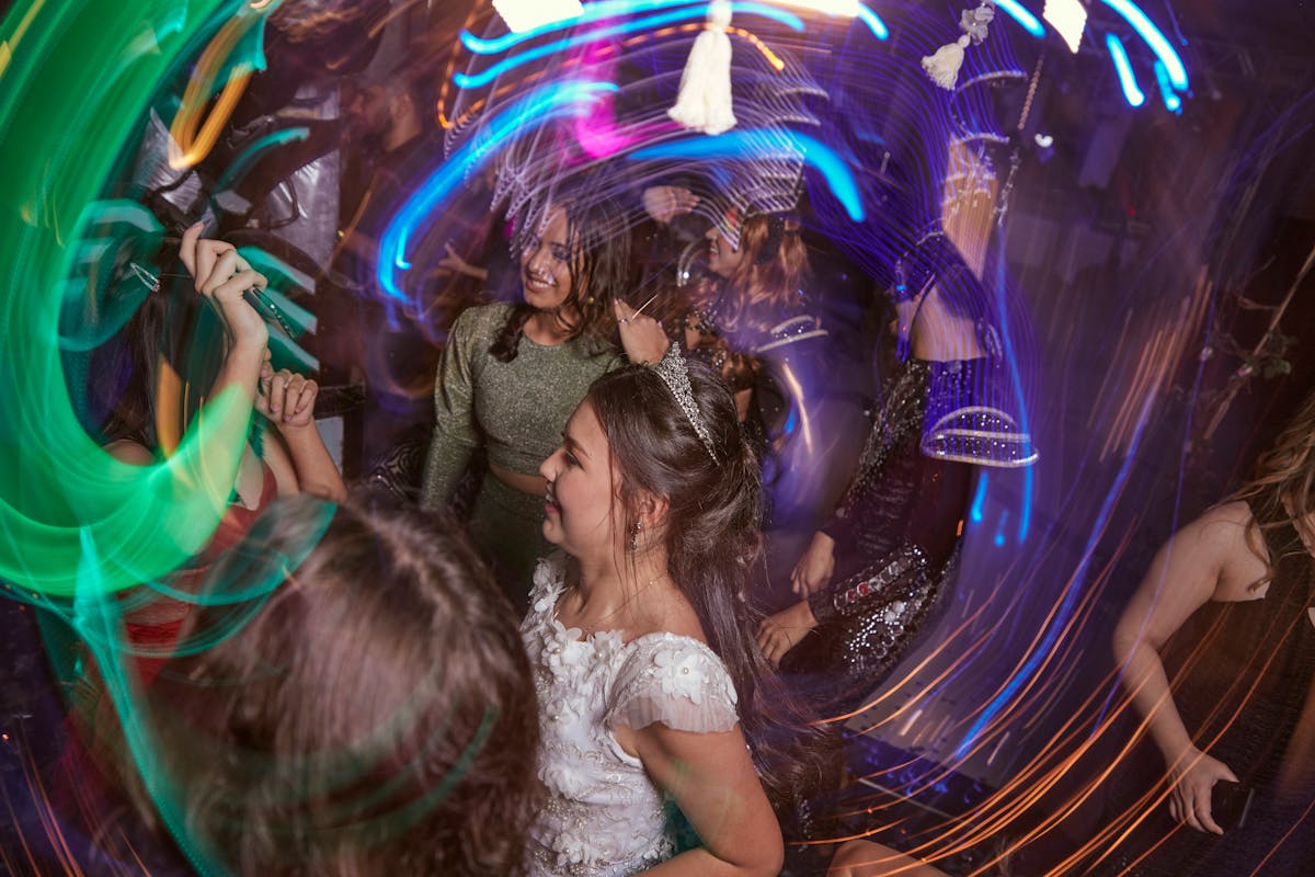 Teenagers dancing with colourful lights at a 13th birthday party celebration