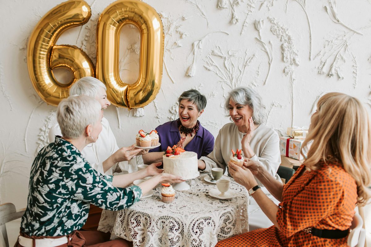Group of women celebrating a 60th birthday party with champagne glasses and happy expressions
