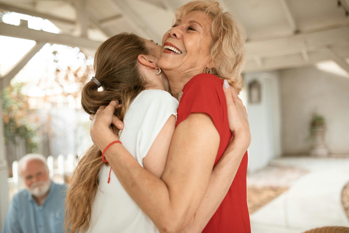 Adult grandchild hugging grandmother warmly at a birthday celebration