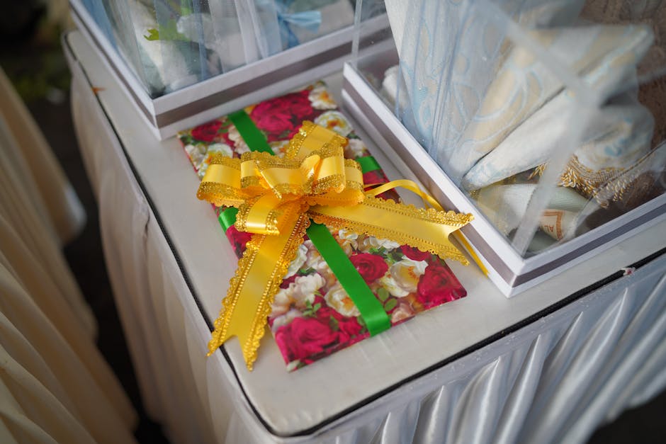 A beautifully wrapped birthday gift with a yellow bow on a decorated table, warm, contemporary adult gift presentation