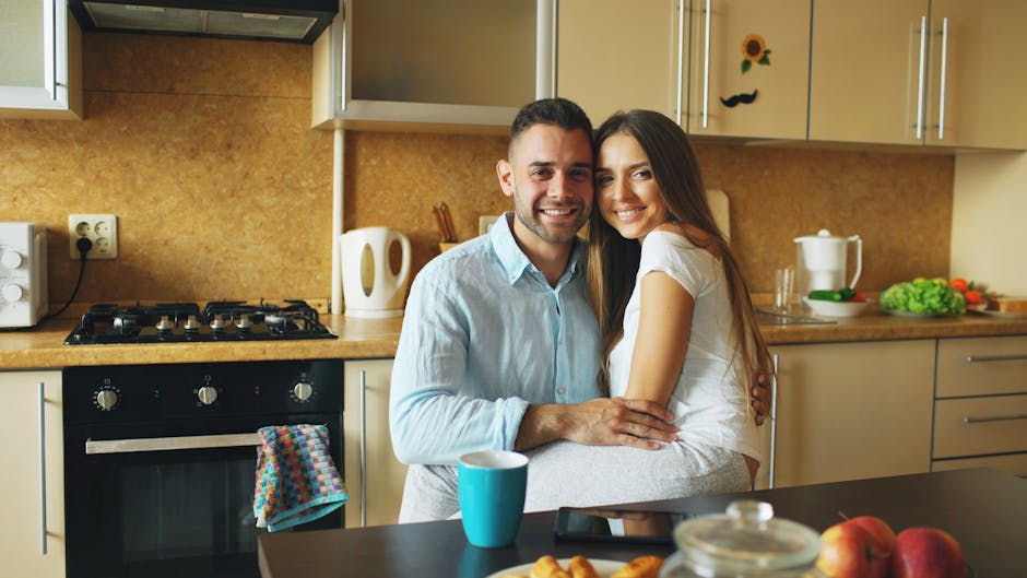A happy couple sharing a warm, casual moment together in a cosy kitchen, relaxed and genuine, not posed