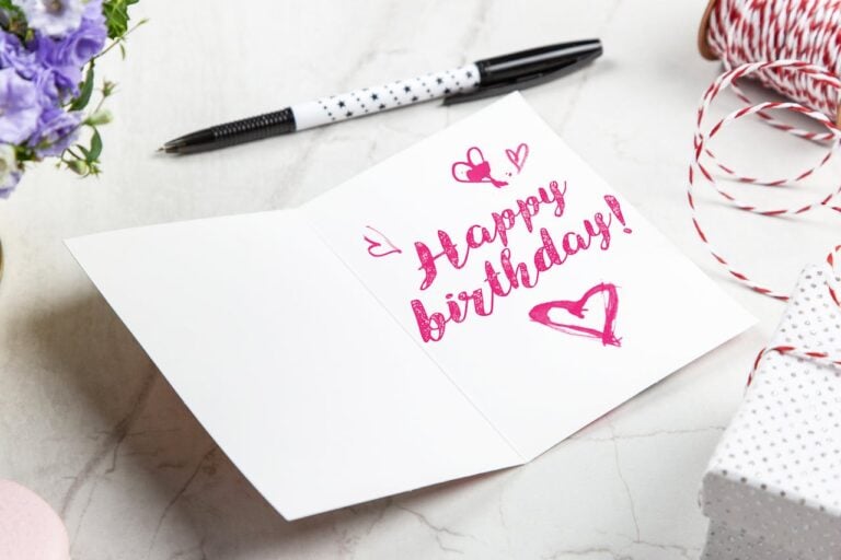 Open birthday greeting card beside a pen, ready to write a heartfelt message