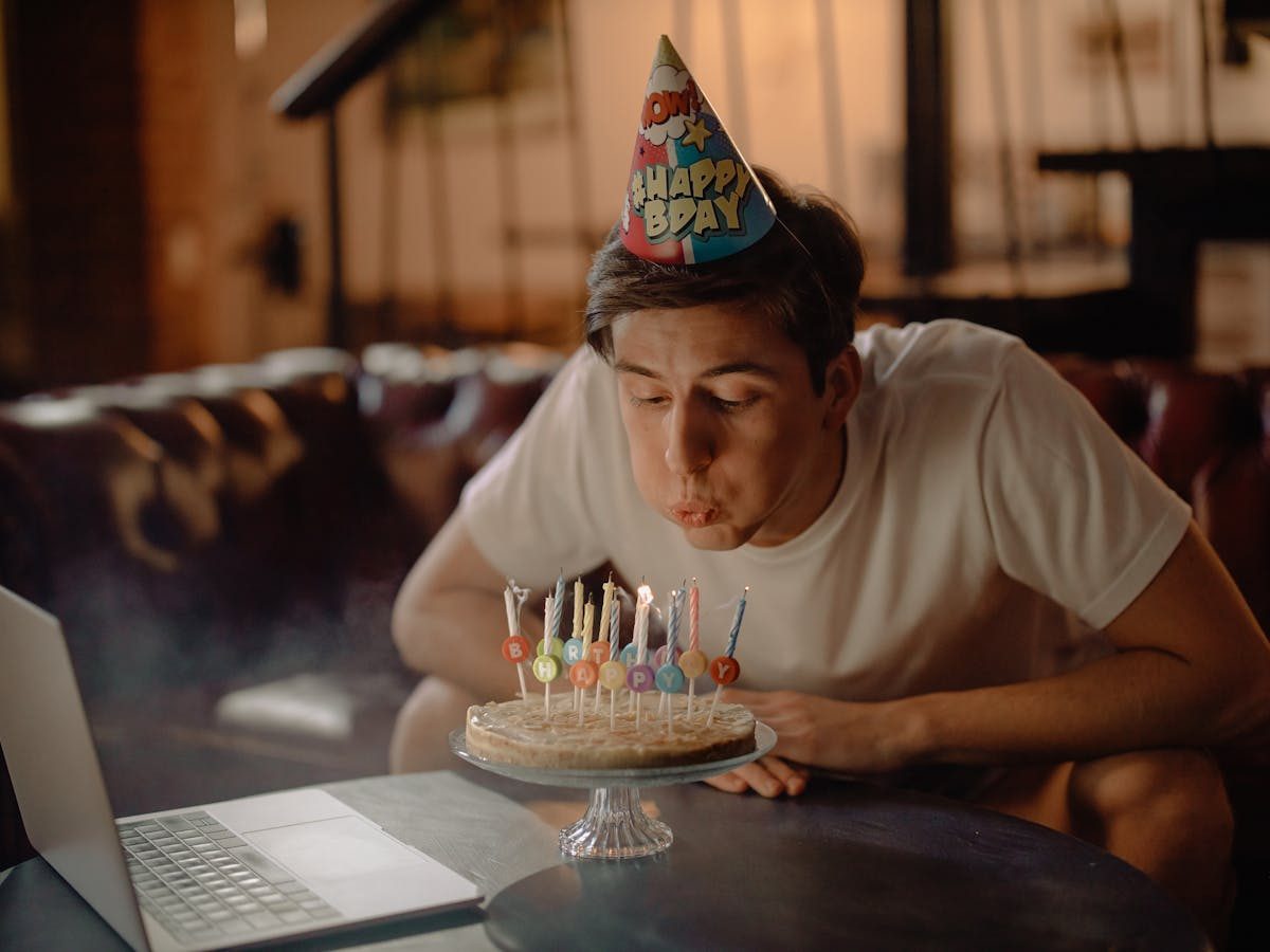 Group of adults celebrating a birthday together with cake and candles