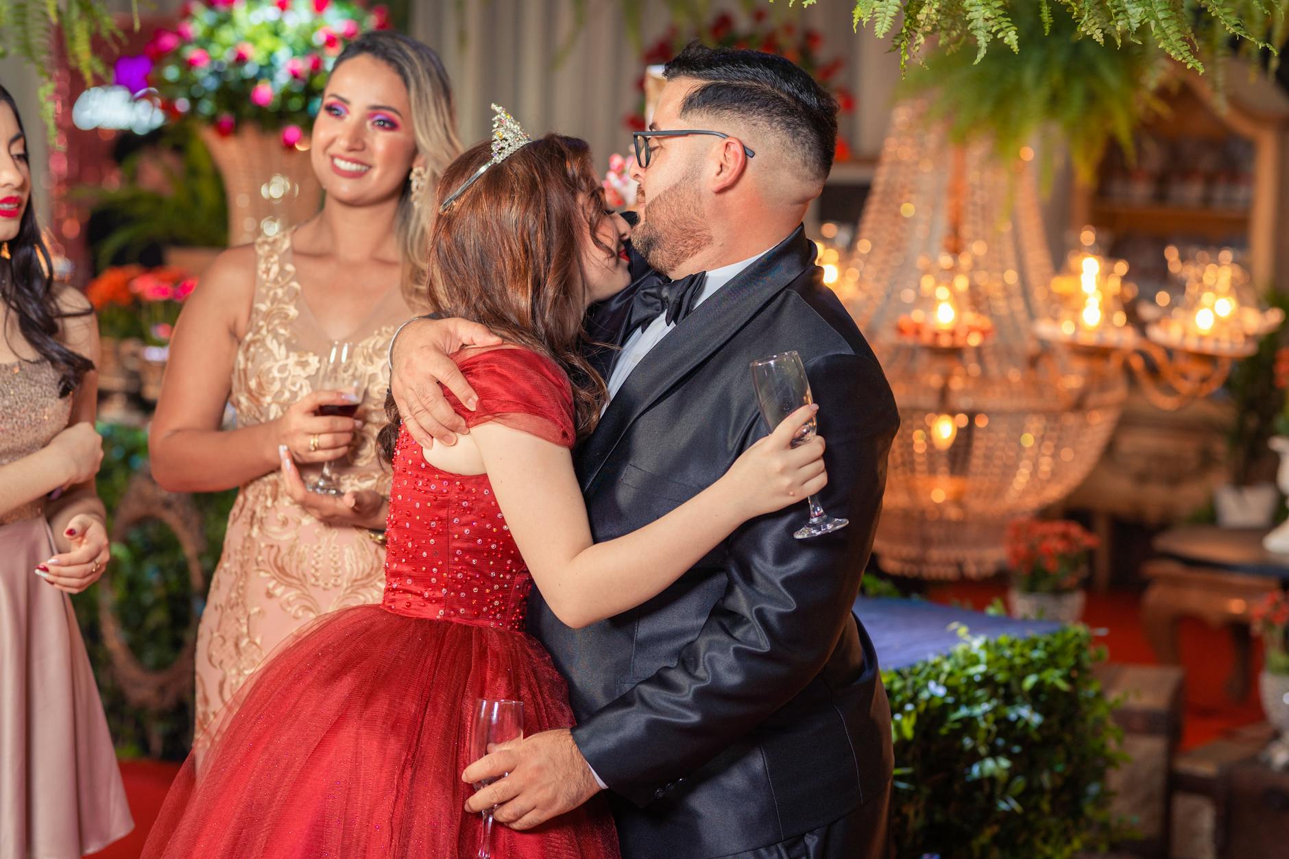 Adults in formal attire celebrating with champagne at a glamorous indoor birthday party