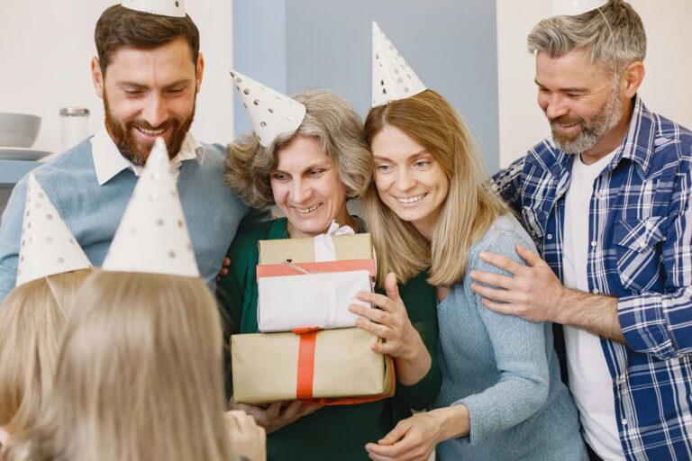 Multi-generational family celebrating grandmothers birthday with gifts and party hats