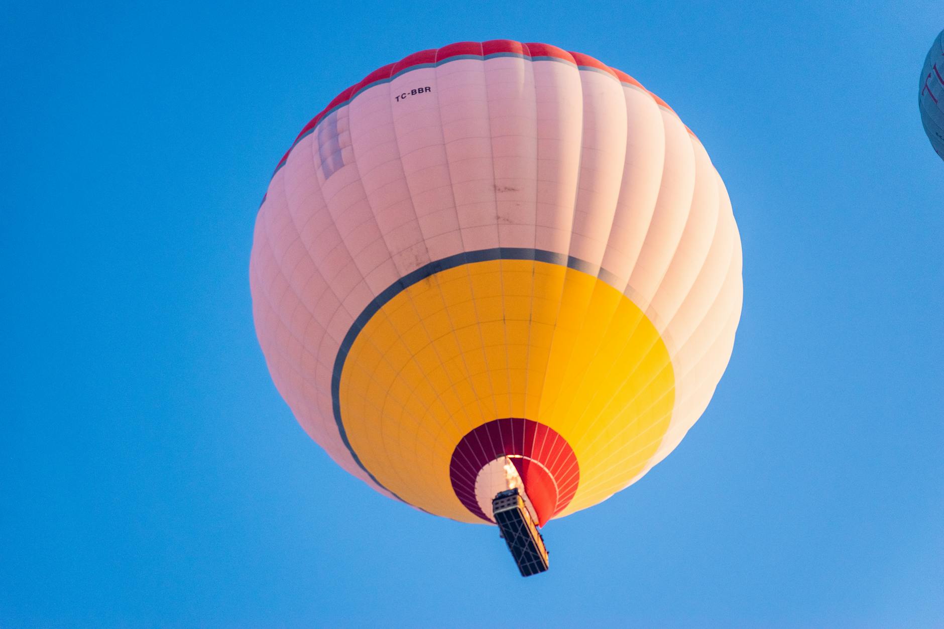 Vibrant hot air balloon ascending in a clear blue sky, representing a hot air balloon ride birthday experience gift