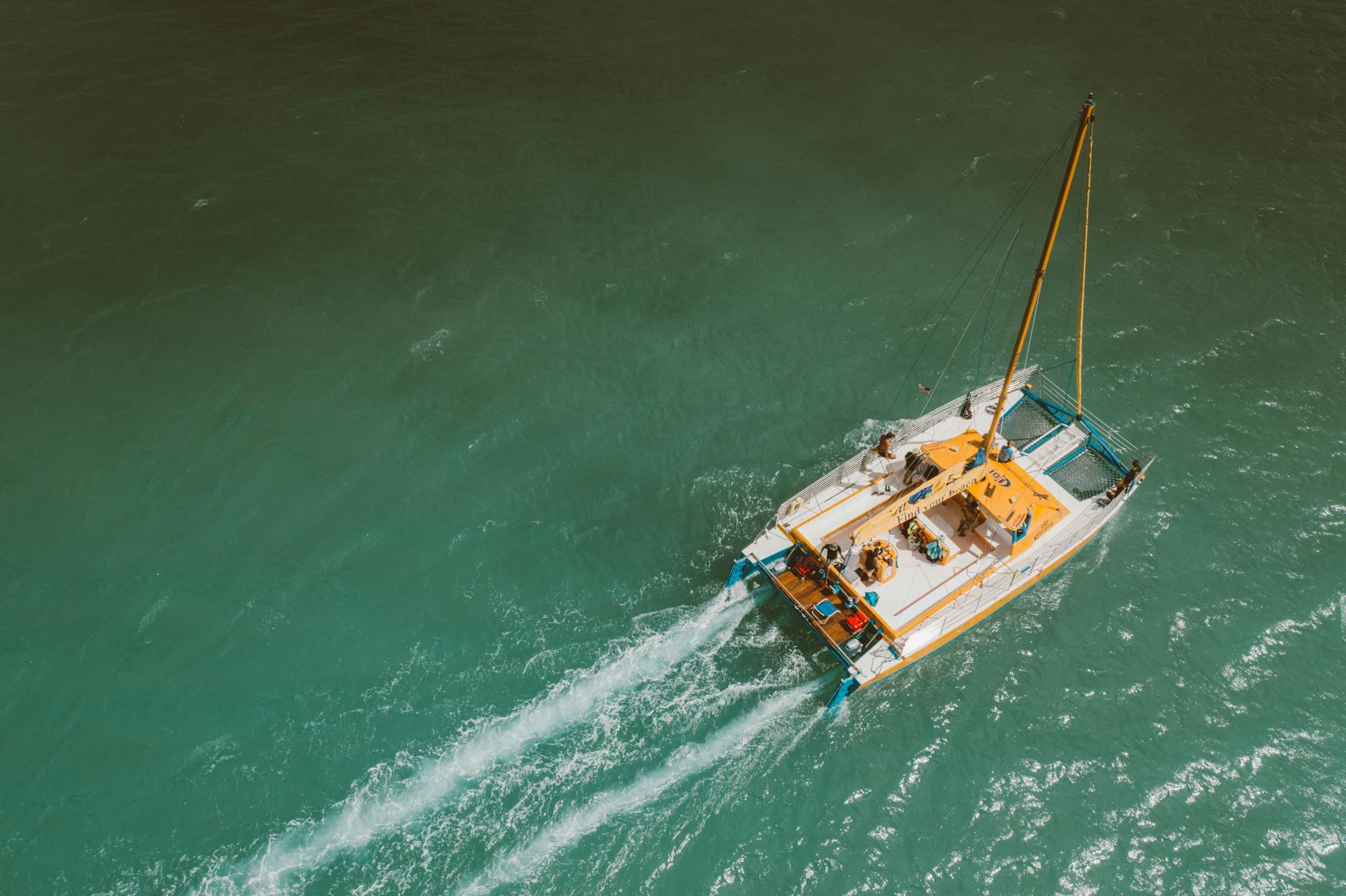 Aerial view of a sailing yacht on clear turquoise water, representing a sailing trip as a birthday experience gift