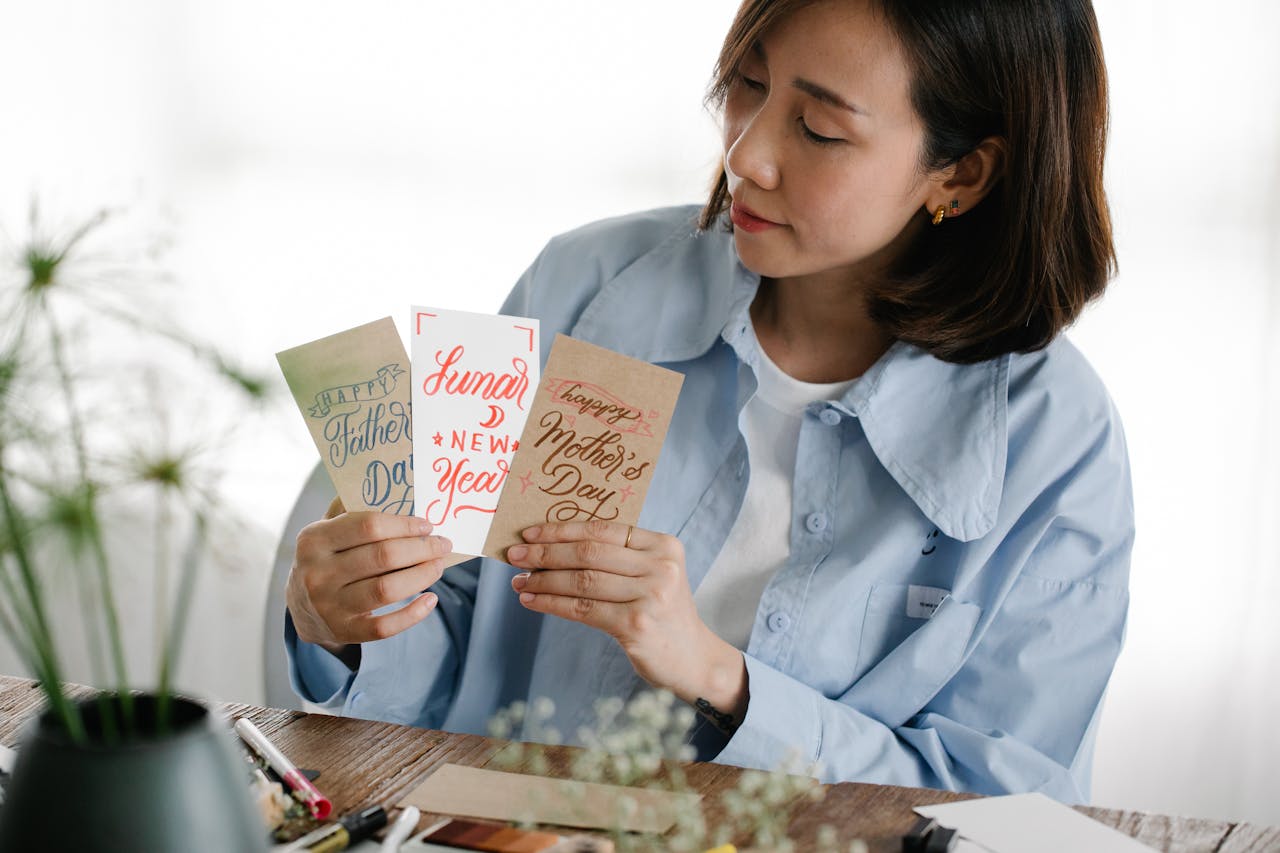 Woman holding handmade birthday cards, showing the personal touch of a handwritten message